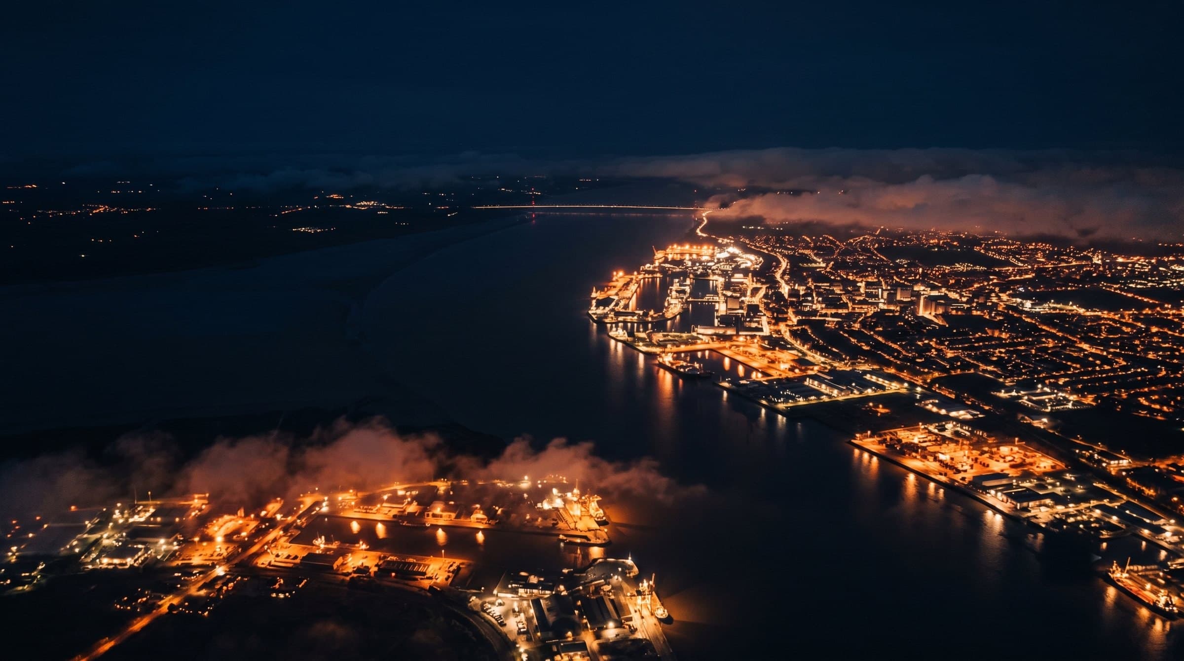 Aerial night view of the Humber estuary and port, city and dockside lights glowing along the water